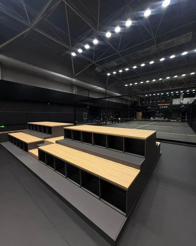 Courtside seating with storage cubbies under the stadium lights